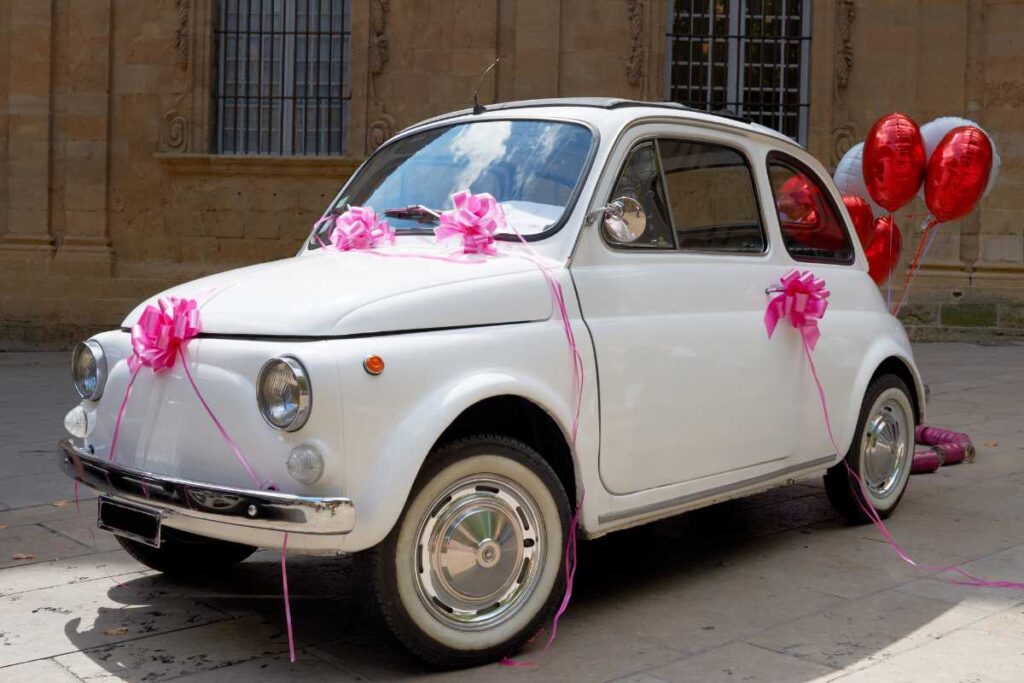 Une voiture de mariage décorée avec des ballons et des rubans